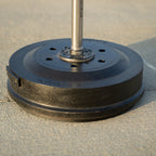Black weight plate with a metal bar on a concrete floor