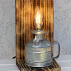 Vintage-style lamp with a wooden base and metal container on a textured wall background