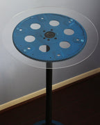 Blue gear on a stand against a gray background