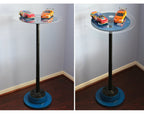 Glass table with toy cars on a plain background