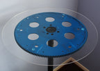 Blue gear on a clear glass table with a neutral background