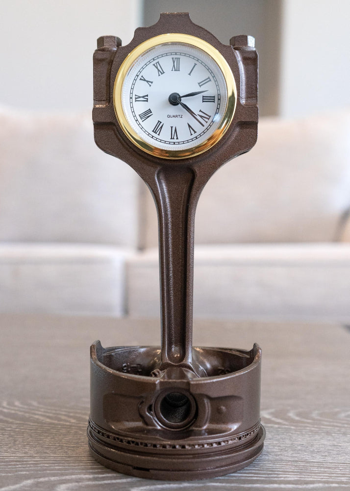 Decorative clock shaped like a piston on a wooden surface