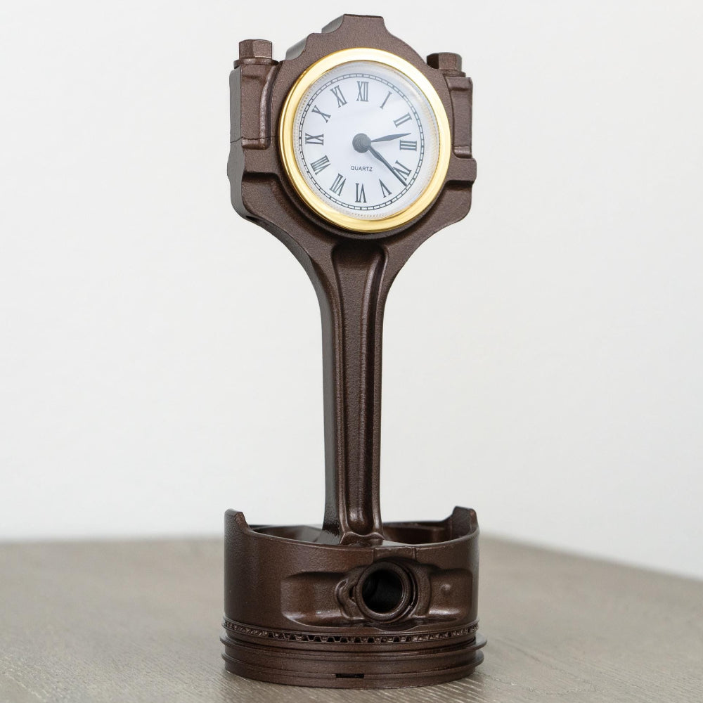 Decorative clock designed like a piston on a white background