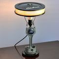 Lamp made from a vintage engine component on a white background