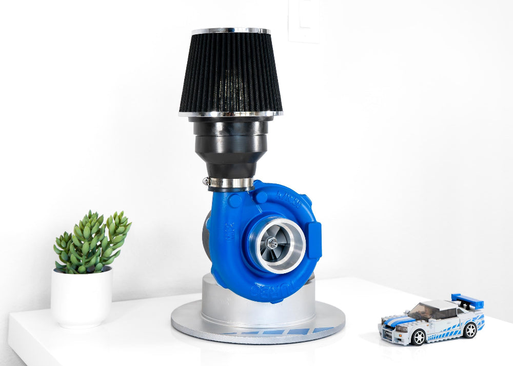 Mechanical component with blue casing and black top on a white background