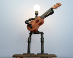 Ukulele lamp made from pipes with a light bulb on a white background