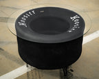 Black fire pit table with glass top on a stone patio