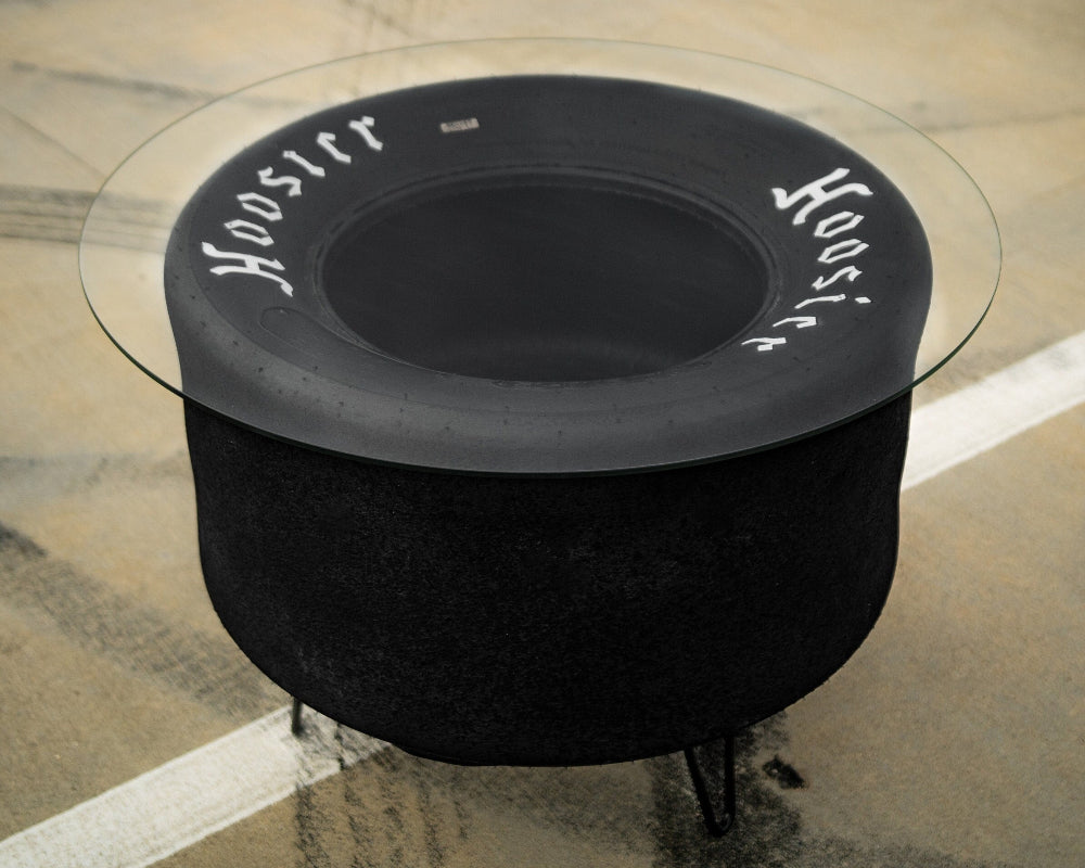 Black fire pit table with glass top on a stone patio