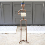 Decorative metal stand with a plant on top in a room with gray cabinets and a rug.