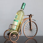 Wine bottle in a decorative bicycle holder against a plain background