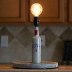 Bottle of Michelob Ultra with a light bulb on top, set against a kitchen background.