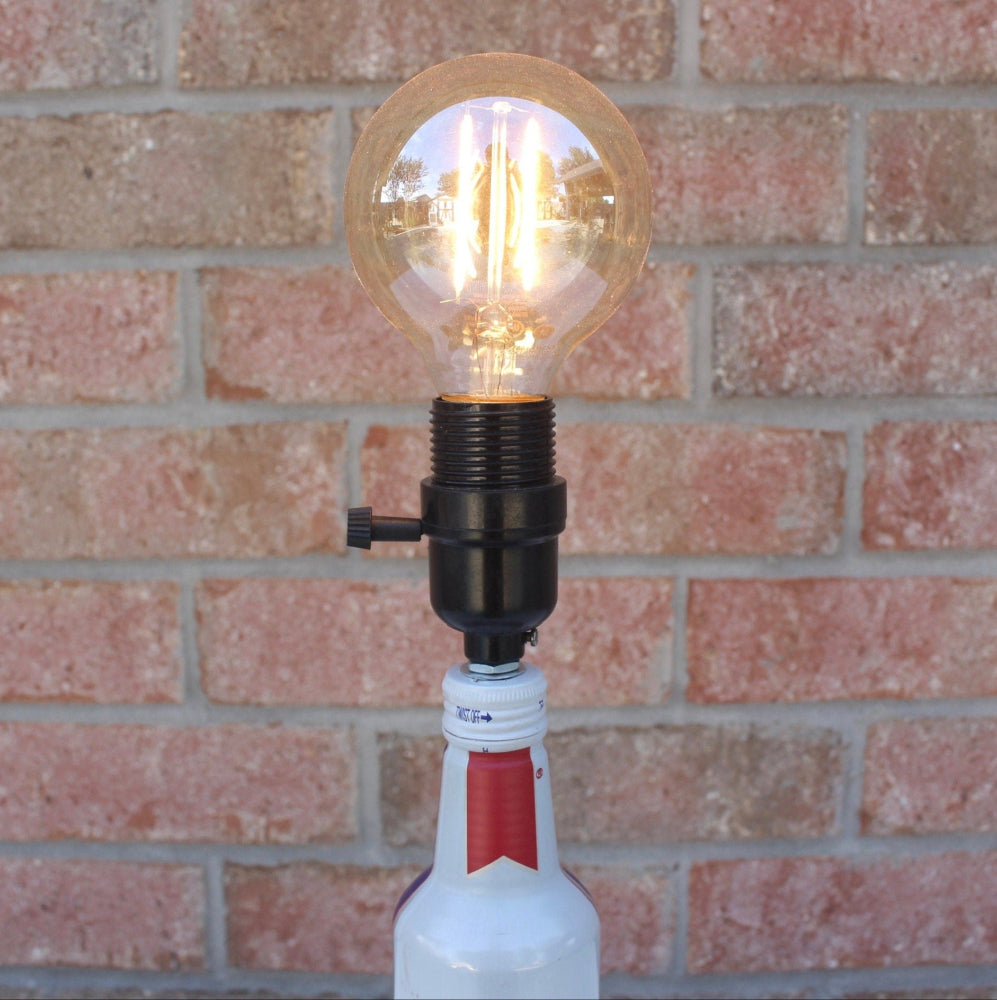 Light bulb on a bottle against a brick wall