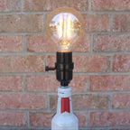 Light bulb on a bottle against a brick wall