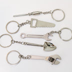 Set of metal keychains shaped like tools on a white background