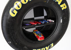 Large black tire with yellow text containing small model cars inside