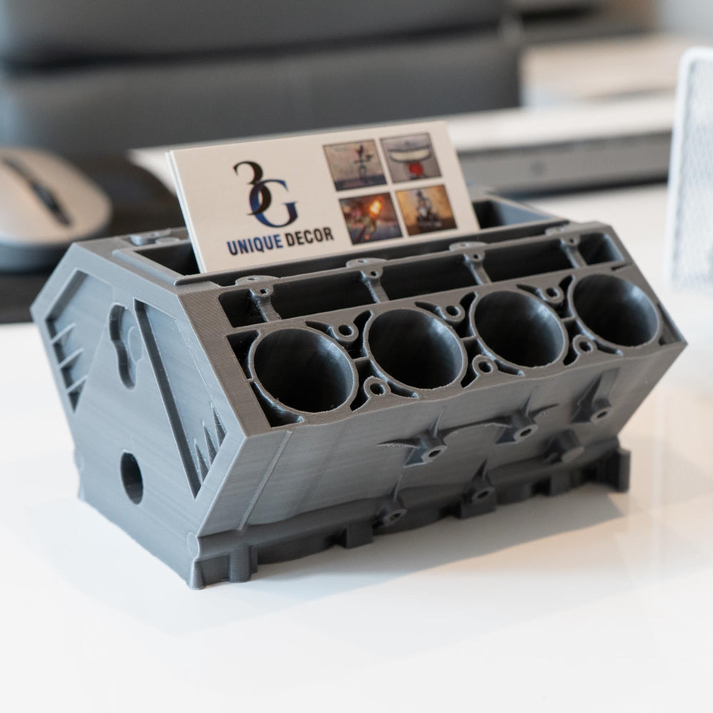 Gray engine block-shaped holder with business cards on a desk