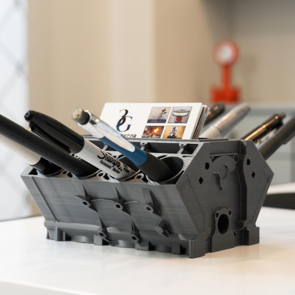 Black office supply organizer with stationery items on a desk