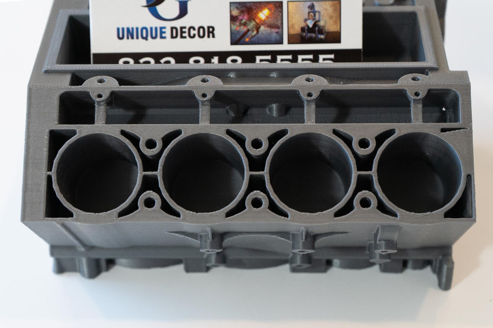 Gray metal engine block mold with 'Unique Decor' branding on a white background