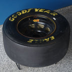 Goodyear racing tire on a gray surface with a blue background