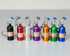 Set of colorful NOS bottle keychains on a gray background