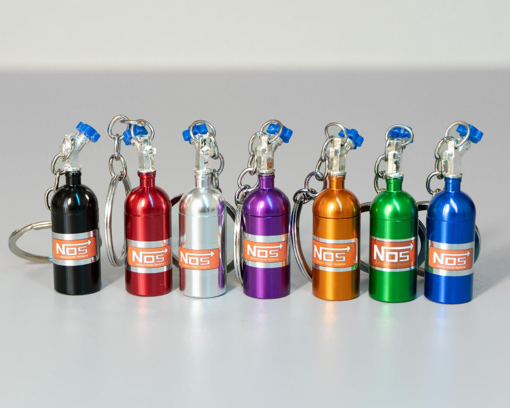 Set of colorful NOS bottle keychains on a gray background