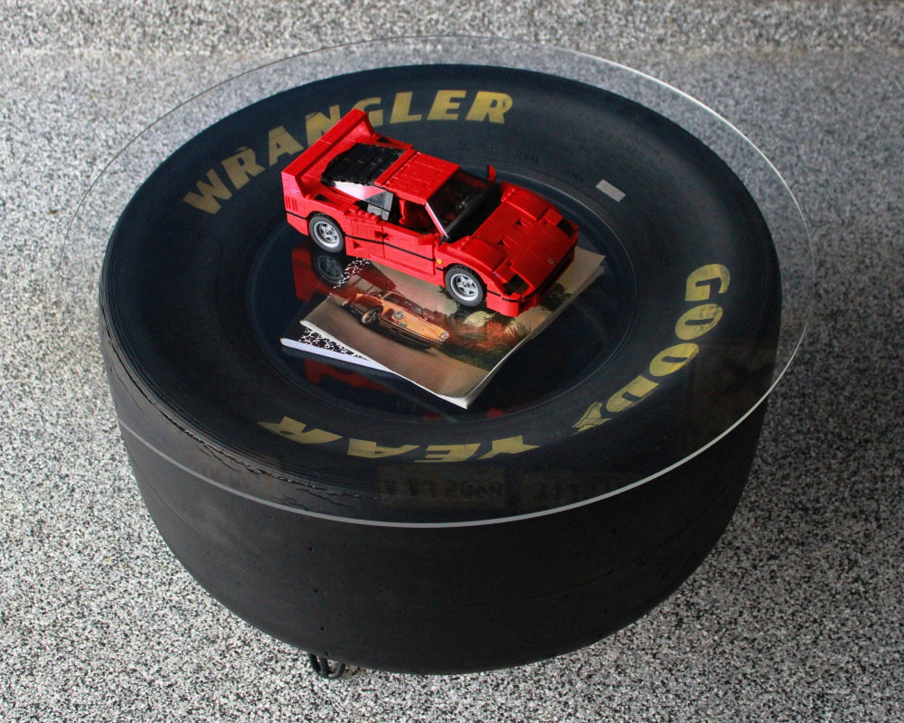 Red toy car on a black tire with 'Wrangler' branding