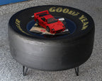 Round ottoman made from a Goodyear tire with a red car model on top