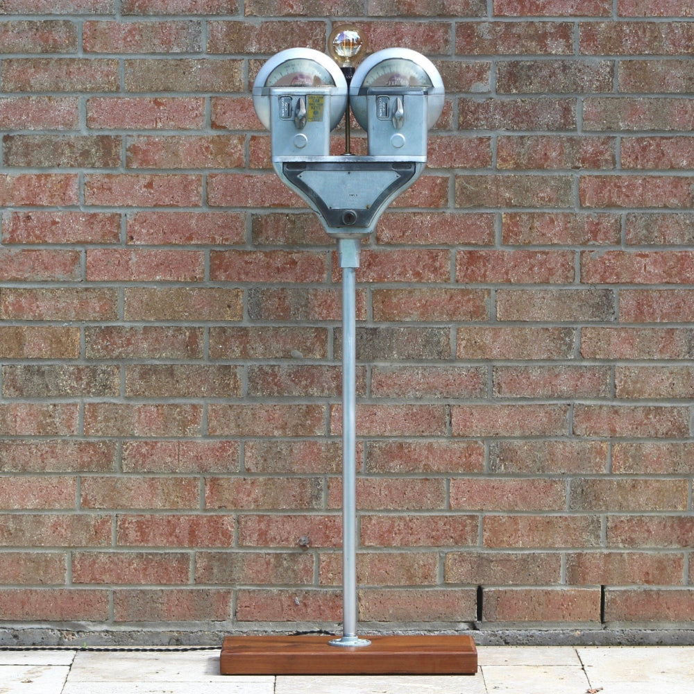 Metal sculpture of a face against a brick wall