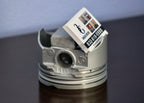 Metallic piston with a business card on a reflective surface