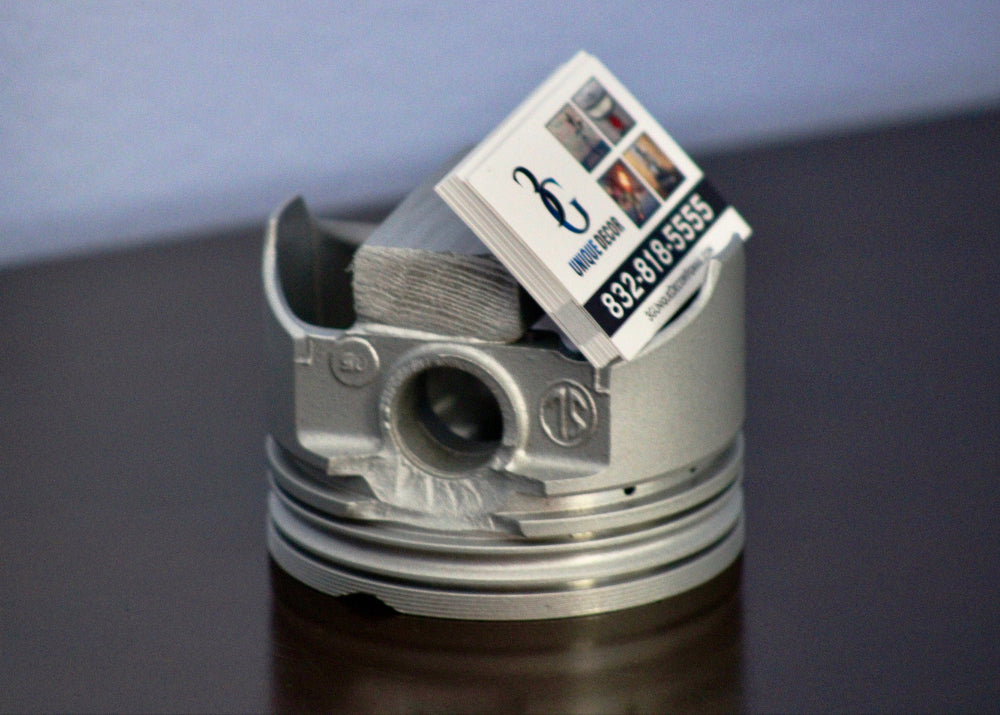 Metallic piston with a business card on a reflective surface
