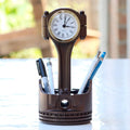 Desk organizer with clock and pens on a table outdoors