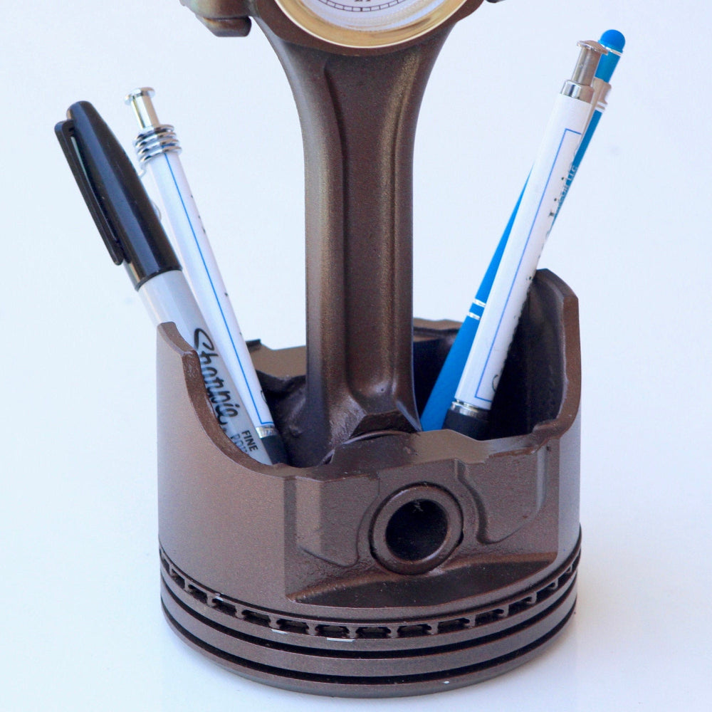 Piston-shaped pen holder with pens on a white background
