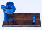 Blue metal component on a wooden board against a white background