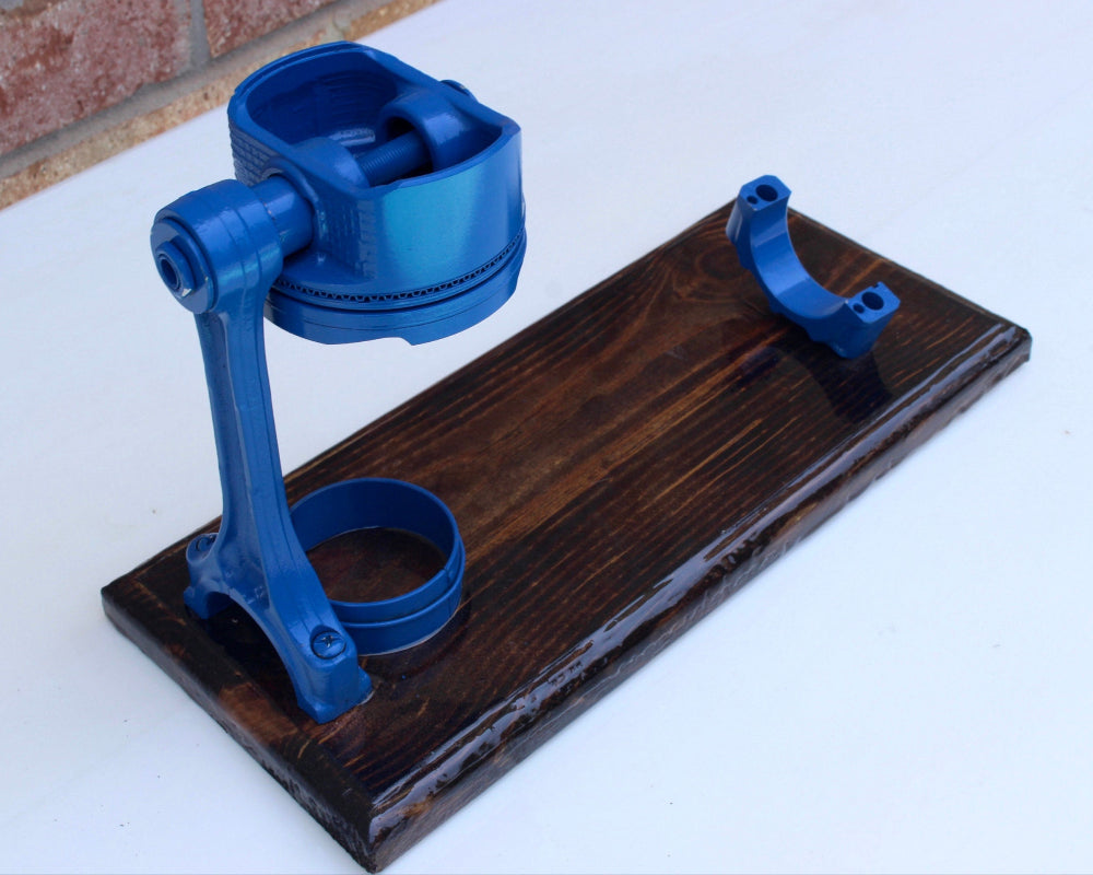 Blue plastic components on a wooden stand with a white background
