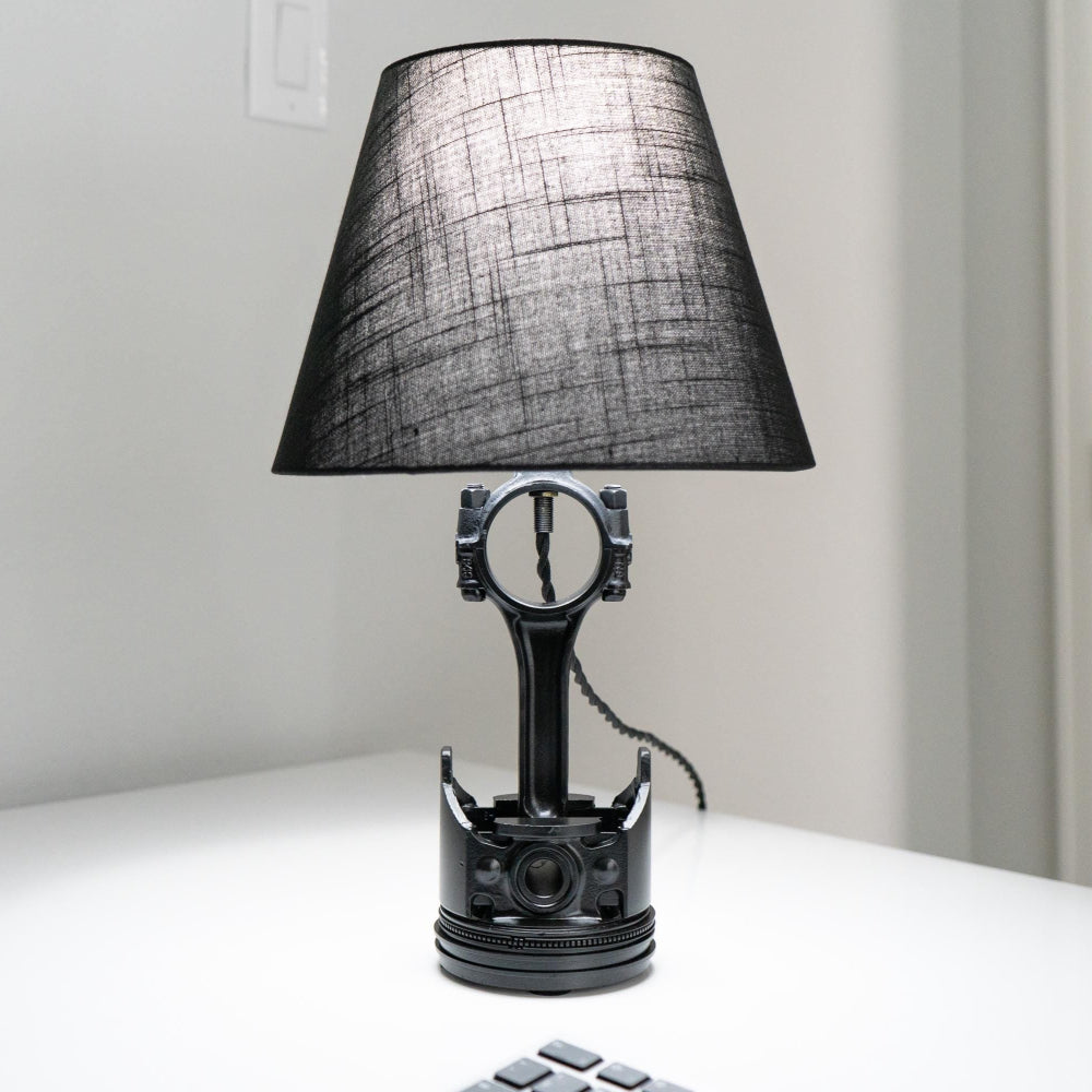 Black table lamp with a unique design on a white surface.