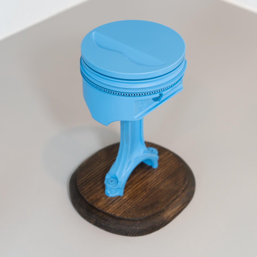 Blue object on a wooden base with a white background