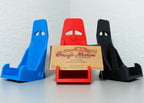 Three car window holders in blue, red, and black with a cardboard sign in the center.