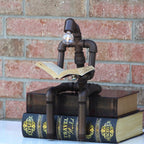 Decorative lamp made from pipes and books against a brick wall.