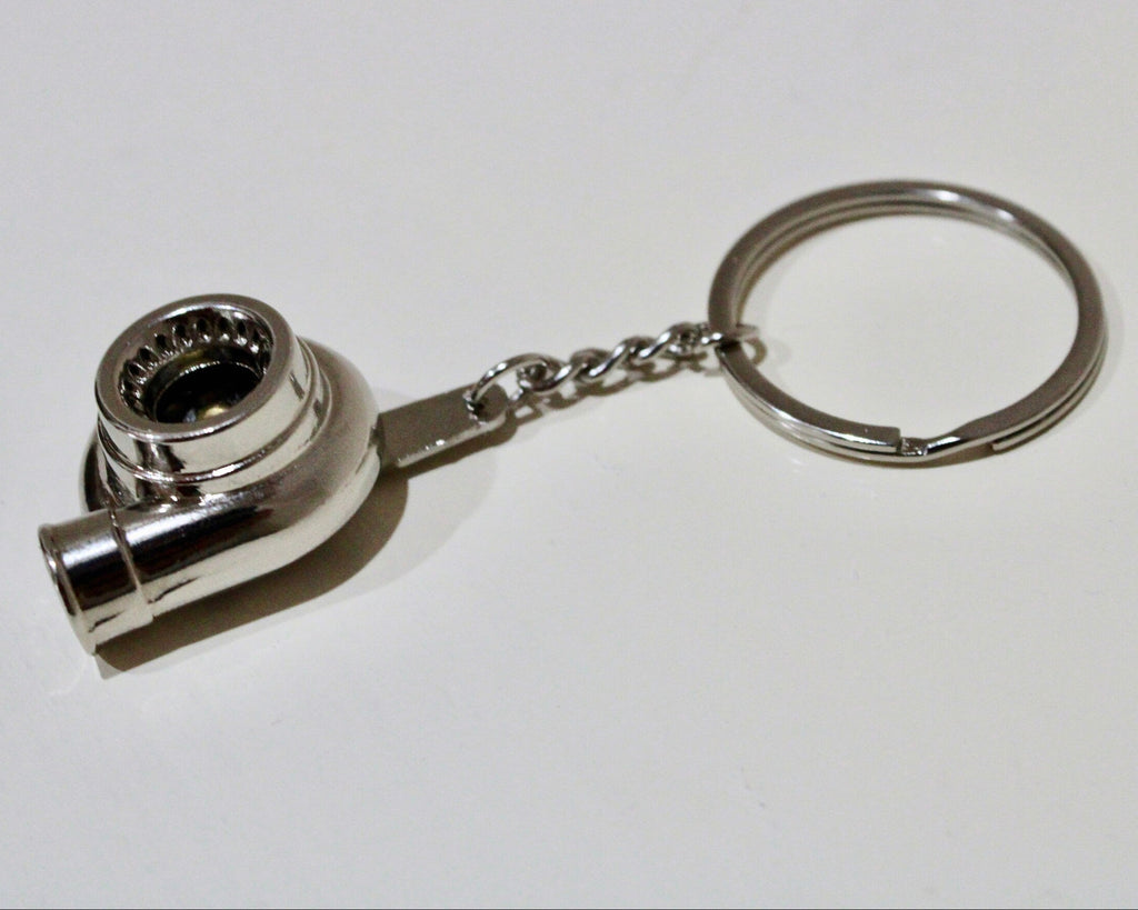 Metal keychain shaped like a turbocharger on a white background