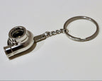 Metal keychain shaped like a turbocharger on a white background