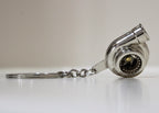 Turbocharger keychain on a white surface with a neutral background