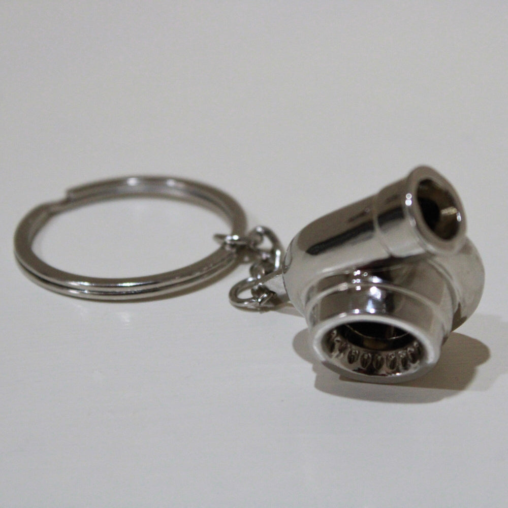 Metallic keychain shaped like a turbocharger on a white background
