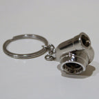 Metallic keychain shaped like a turbocharger on a white background
