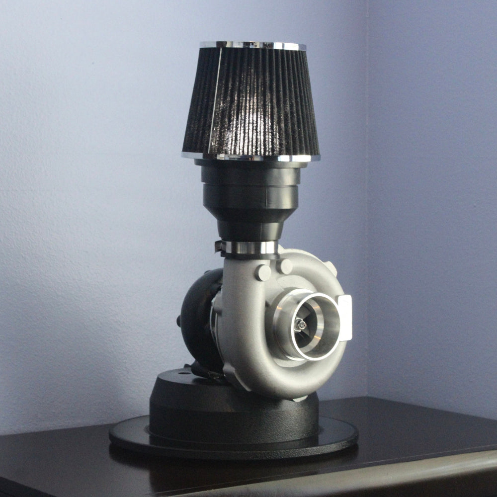 Lamp made from a turbocharger on a dark surface with a light blue wall background
