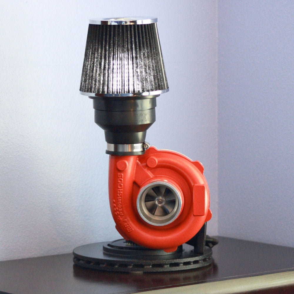 Turbocharger repurposed as a lamp with a black and silver shade on a white background