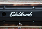 Edelbrock logo on a black surface with a wooden background