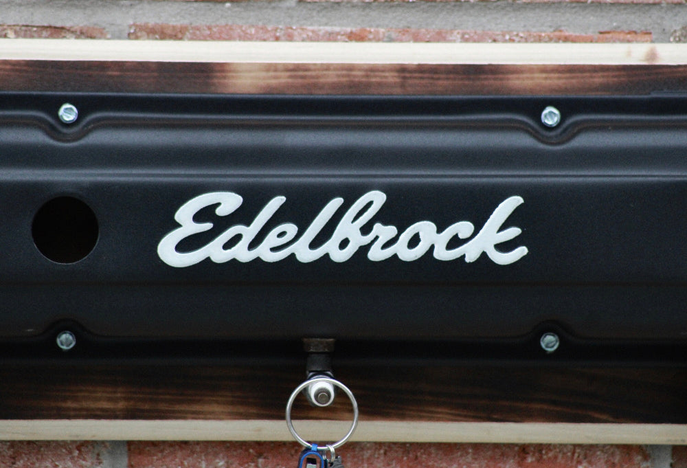 Edelbrock logo on a black surface with a wooden background