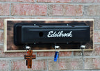 Edelbrock oil pan wall mount with hooks on a brick wall