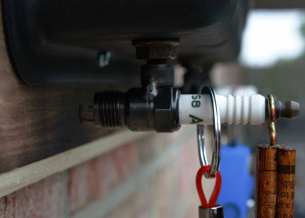 Close-up of a valve with a carabiner attached, set against a blurred outdoor background.