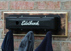 Edelbrock exhaust system mounted on a brick wall